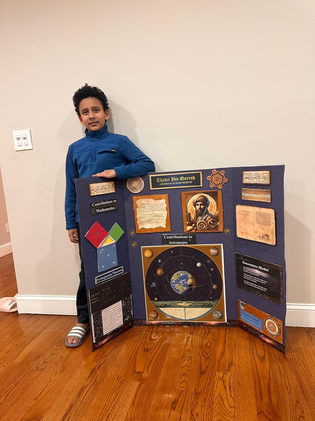 A child standing next to a blue tri-fold presentation board
